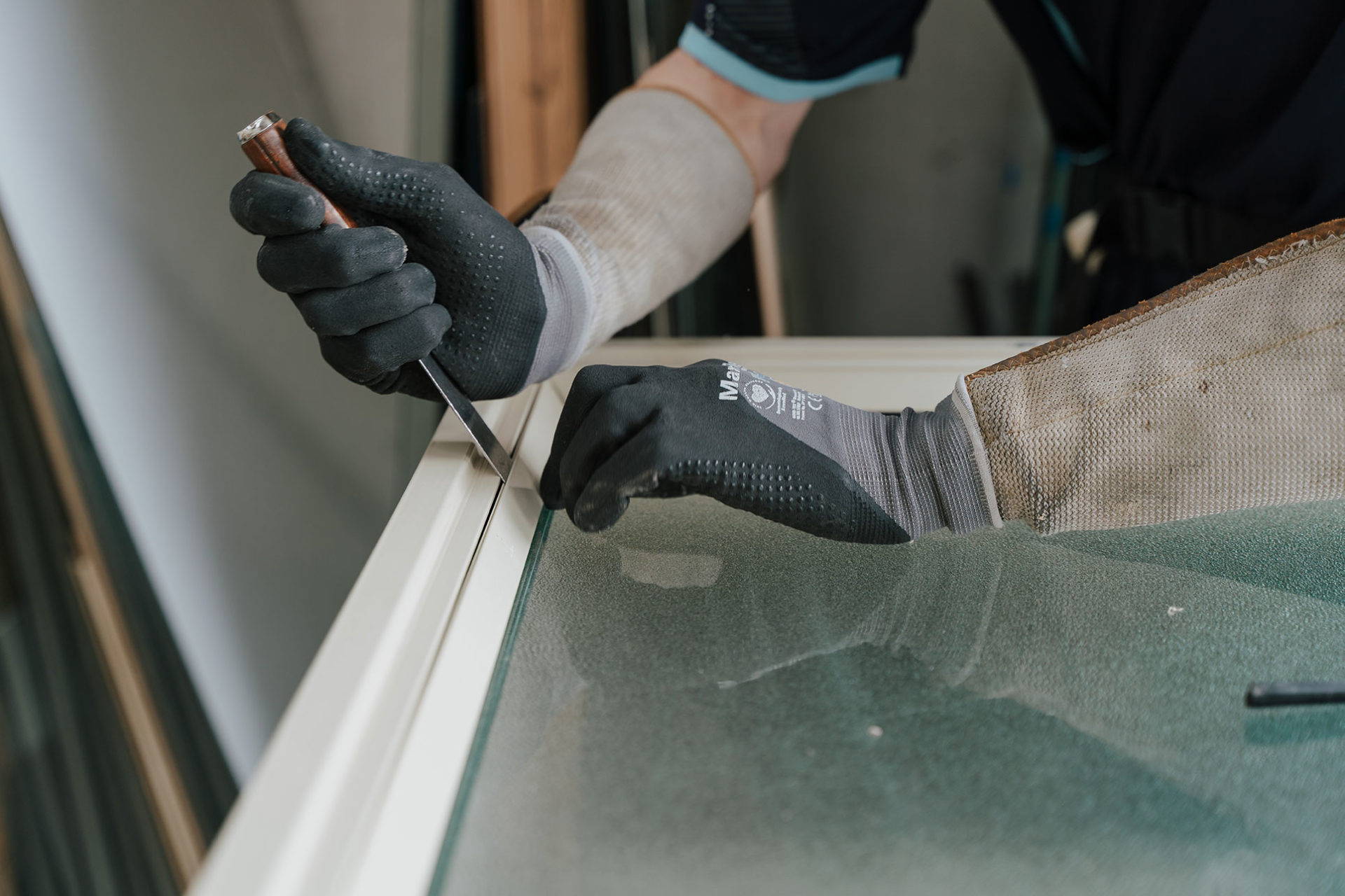 Glazier removing a pane from a window frame